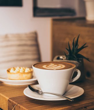 Fincan kahve ve kek bir kafede ahşap bir masa üzerine