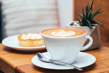 Fincan kahve ve kek bir kafede ahşap bir masa üzerine