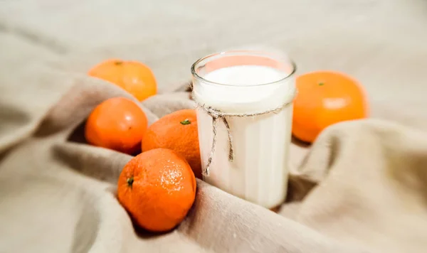 Zářivě Oranžové Mandarinky Sklenici Mléka Pozadí Lněné Tkaniny — Stock fotografie