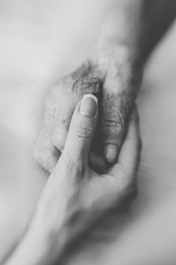 Yardım eli. Genç bir kadının el dikkatle yaşlı bir kadının kırışmış el destekler