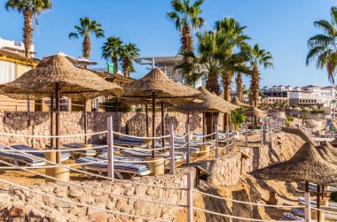Sharm El Sheikh, Sinai, Mısır - 18 Aralık 2018: Güzel güneşli bir plaj ve güneş şemsiyeleri şehir Sharm El Sheikh, Mısır'ın Kızıldeniz kıyısında. Sina Yarımadası'nda Turizm rekreasyon alanı