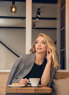 Bir fincan kahve bir kafede güzel genç sarışın kadınla