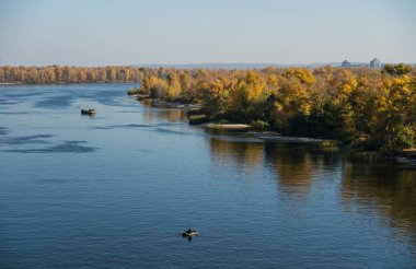 Nehir, mavi gökyüzü ve orman. Güzel güneşli sonbahar manzara