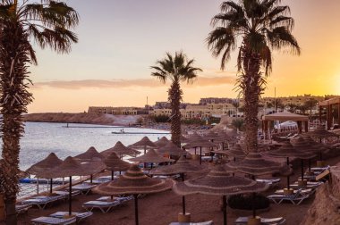 Sharm El Sheikh, Sinai, Mısır - 18 Aralık 2018: Güzel güneşli bir plaj ve güneş şemsiyeleri şehir Sharm El Sheikh, Mısır'ın Kızıldeniz kıyısında. Sina Yarımadası'nda Turizm rekreasyon alanı
