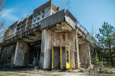 Pripyat 'ın terk edilmiş hayalet kasabasının sokağı. Çernobil nükleer felaketinin yasak bölgesindeki ağaçlar ve yıkılan evler.