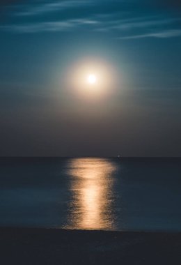 Moonlit night over the sea. Full moon and lunar path clipart