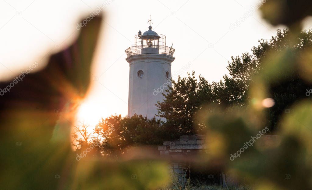 Tower of the old lighthouse against the evening sky. Countryside landscape