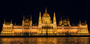 Budapeşte / Macaristan - 29 Ağustos 2019: Gece Budapeşte'de Macar Parlamentosu binası ve Tuna Nehri. Neo-gotik mimarinin bir örneği, Budapeşte'nin turistik cazibe