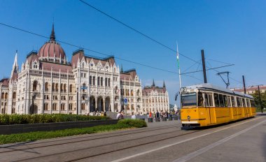 Budapeşte / Macaristan - 29 Ağustos 2019: Budapeşte'deki Macar Parlamento Binası önünde eski sarı tramvay. Macaristan'ın başkentinin tarihi merkezi. Budapeşte'de toplu taşıma