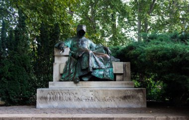 Budapeşte, Macaristan - 30 Ağustos 2019: Gizemli Anonymous'un bronz heykeli, Macaristan'ın antik tarihinin efsanevi tarihçisi. Budapeşte'deki Tarihi Park Varoshliget'in manzarası. 1896 yılında Macar devletinin Milenyum