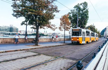 Budapeşte / Macaristan - 29 Ağustos 2019: Budapeşte'deki Macar Parlamento Binası önünde eski sarı tramvay. Macaristan'ın başkentinin tarihi merkezi. Budapeşte'de toplu taşıma