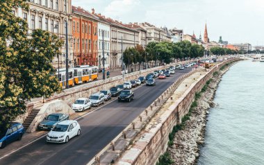 Budapeşte, Macaristan - 29 Ağustos 2019: Budapeşte, Macaristan'da rıhtımda eski evlerin otoyol ve cepheleri. Yoğun saatlerde Tuna Nehri boyunca bir şehir caddesi boyunca araba sürmek. Tarihi şehir merkezi ve ünlü turistik