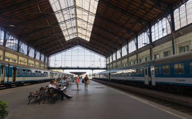 Budapeşte, Macaristan - 29 Ağustos 2019: Budapeşte, Macaristan 'daki eski Nyugati Palyaudvar tren istasyonu ve yolcu vagonları platformu. Avrupa 'da demiryolu toplu taşımacılığı. Eski bina ve istasyon binasında turistler