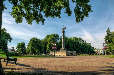 Poltava, Ukrayna - 26 Temmuz 2020: Ukrayna 'nın tarihi Poltava kentindeki Glory Anıtı' nın bronz sütunu ve pitoresk Corpus Parkı. Yaz şehri manzarası. Ukrayna 'da popüler turizm merkezi
