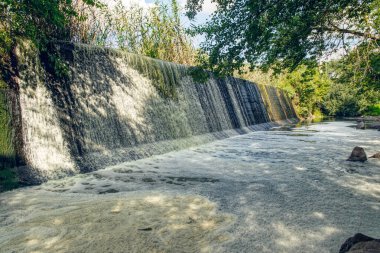 Ukrayna 'nın Buky köyündeki Tikich Dağı nehrindeki terk edilmiş bir hidroelektrik santralinin eski taş barajı. Resimli kırsal alan ve akan fırtınalı suyun taze akışı