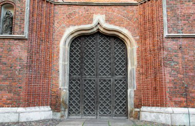 Gdansk 'taki ortaçağ gotik kilisesinin tahta kapısı ve tuğla duvarı.
