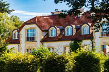 Gdansk, Polonya - 20 Eylül 2025: yeşil yaz bahçesinin arasında güzel bir varlıklı banliyö evi. Avrupa mimarisi ve şehir hayatı