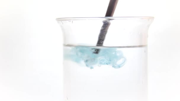 La peinture dans l'eau est bleue. Dissolution sur fond blanc 