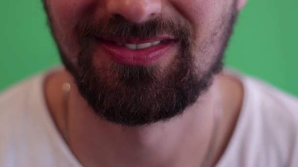 Молодой парень показывает зубы дантисту с зеленым фоном — стоковое видео