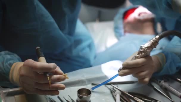 牙医正在为牙科诊所的病人准备牙齿植入工具 医生正在使用医疗技术 医生的团队合作 医疗保健理念 — 图库视频影像