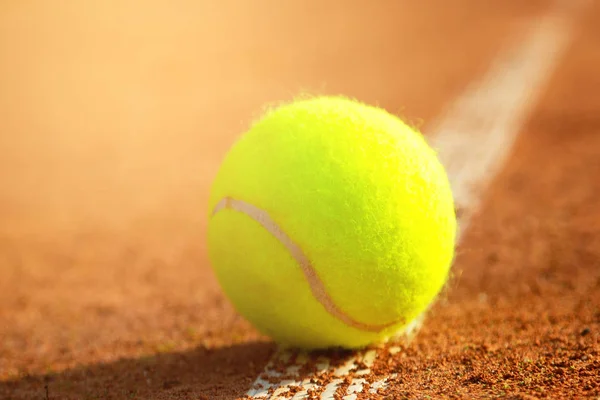 Palla da tennis close-up e rete sul campo con luce solare sullo sfondo — Foto Stock