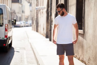 Rahat kentsel tarzı logo veya tasarım alanı olan beyaz boş t-shirt giyen sakallı hippi yakışıklı erkek modeli