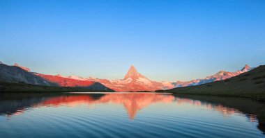 İsviçre 'nin Zermatt şehrinde beyaz kar ve mavi gökyüzü ile Matterhorn Dağı