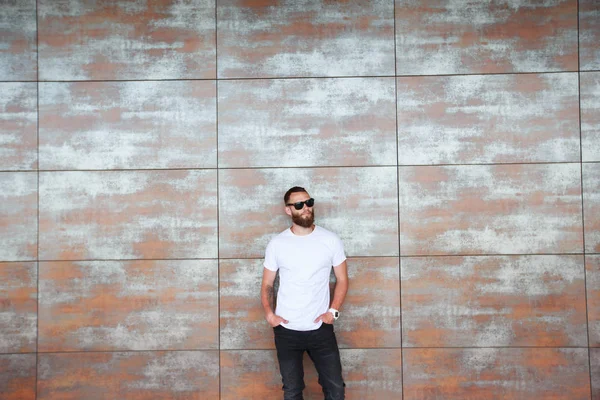 Sakallı, beyaz, boş tişörtlü, beysbol şapkalı, logonuz için yeri olan yakışıklı bir hippi mankeni.