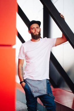 Hipster yakışıklı erkek model beyaz boş t-shirt ve logonuzu yeri olan bir beyzbol şapkası giyen sakallı