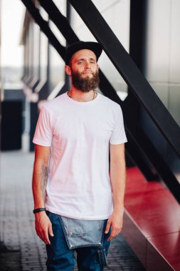 Hipster yakışıklı erkek model beyaz boş t-shirt ve logonuzu yeri olan bir beyzbol şapkası giyen sakallı