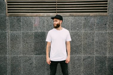 Hipster yakışıklı erkek model beyaz boş t-shirt ve logonuzu yeri olan bir beyzbol şapkası giyen sakallı