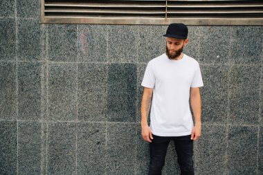 Hipster yakışıklı erkek model beyaz boş t-shirt ve logonuzu yeri olan bir beyzbol şapkası giyen sakallı
