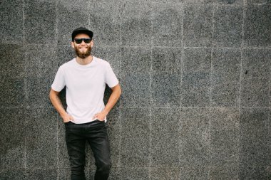 Hipster yakışıklı erkek model beyaz boş t-shirt ve logonuzu yeri olan bir beyzbol şapkası giyen sakallı