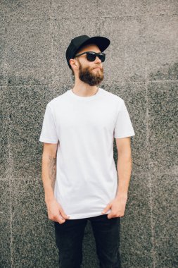 Hipster yakışıklı erkek model beyaz boş t-shirt ve logonuzu yeri olan bir beyzbol şapkası giyen sakallı