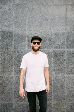 Hipster yakışıklı erkek model beyaz boş t-shirt ve logonuzu yeri olan bir beyzbol şapkası giyen sakallı