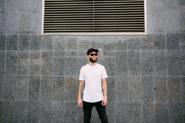 Hipster yakışıklı erkek model beyaz boş t-shirt ve logonuzu yeri olan bir beyzbol şapkası giyen sakallı