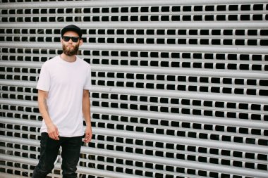 Hipster yakışıklı erkek model beyaz boş t-shirt ve logonuzu yeri olan bir beyzbol şapkası giyen sakallı