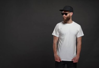 Sakallı, beyaz, boş tişörtlü, beysbol şapkalı, logonuz için yeri olan yakışıklı bir hippi mankeni.