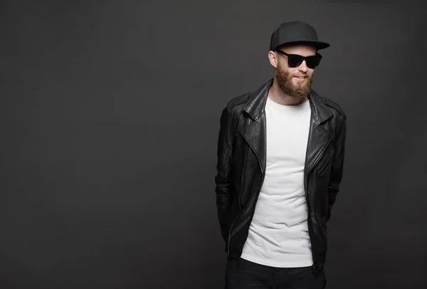 Hipster handsome male model with beard wearing white blank t-shirt and a baseball cap with space for your logo or design in casual urban style — Stock Photo, Image