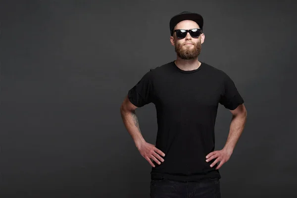 Hipster handsome male model with beard wearing black blank baseball cap with space for your logo — Stock Photo, Image