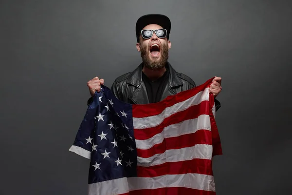 Hombre sosteniendo bandera de EE.UU. sobre fondo gris —  Fotos de Stock