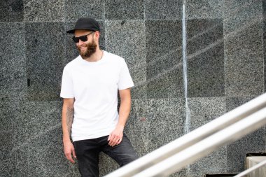 Rahat kentsel tarzda logo veya tasarım için beyaz boş t-shirt alanı giyen sakallı Hipster yakışıklı erkek modeli