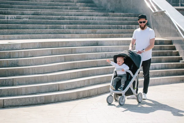 Ojciec spaceru z wózka i dziecko na ulicach miasta — Zdjęcie stockowe