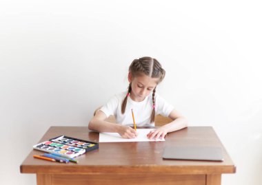 Masada otururken çocuk kız çizim ve resimde evde