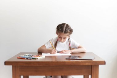 Masada otururken çocuk kız çizim ve resimde evde