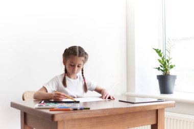 Masada otururken çocuk kız çizim ve resimde evde