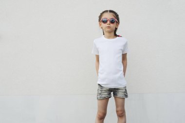 Rahat kentsel tarzı logo veya tasarım alanı olan beyaz t-shirt giyen kız çocuk