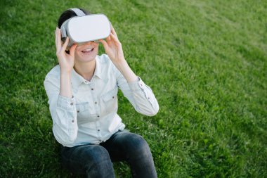 Yeşil çim üzerinde sanal gerçeklik gözlük kullanan kadın