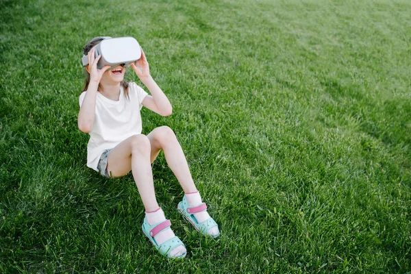 Kid girl using virtual reality glasses outside — Stock Photo, Image