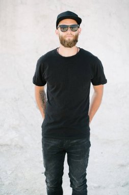 Hippi, sakallı, siyah, boş tişörtlü, logonuz için yeri olan yakışıklı bir erkek model.